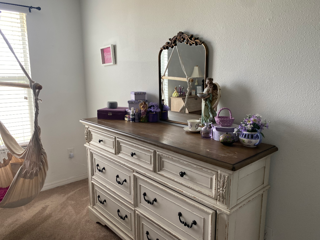 Distressed cream dresser with ornate mirror and purple decor accents