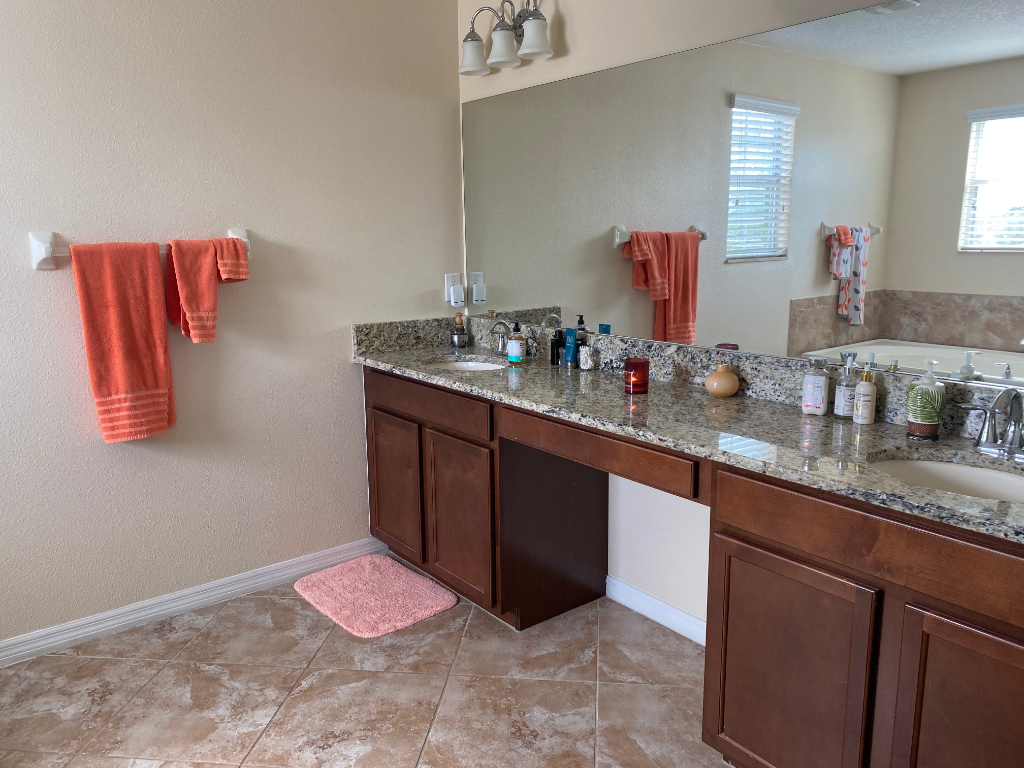 Double-sink bathroom vanity with dark wood cabinets and granite countertop