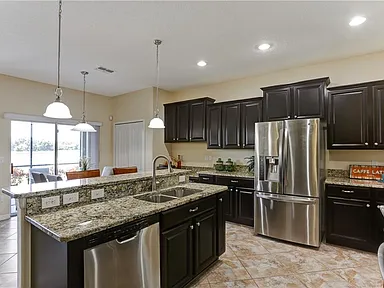 Gourmet kitchen with dark espresso cabinets, granite island, stainless appliances