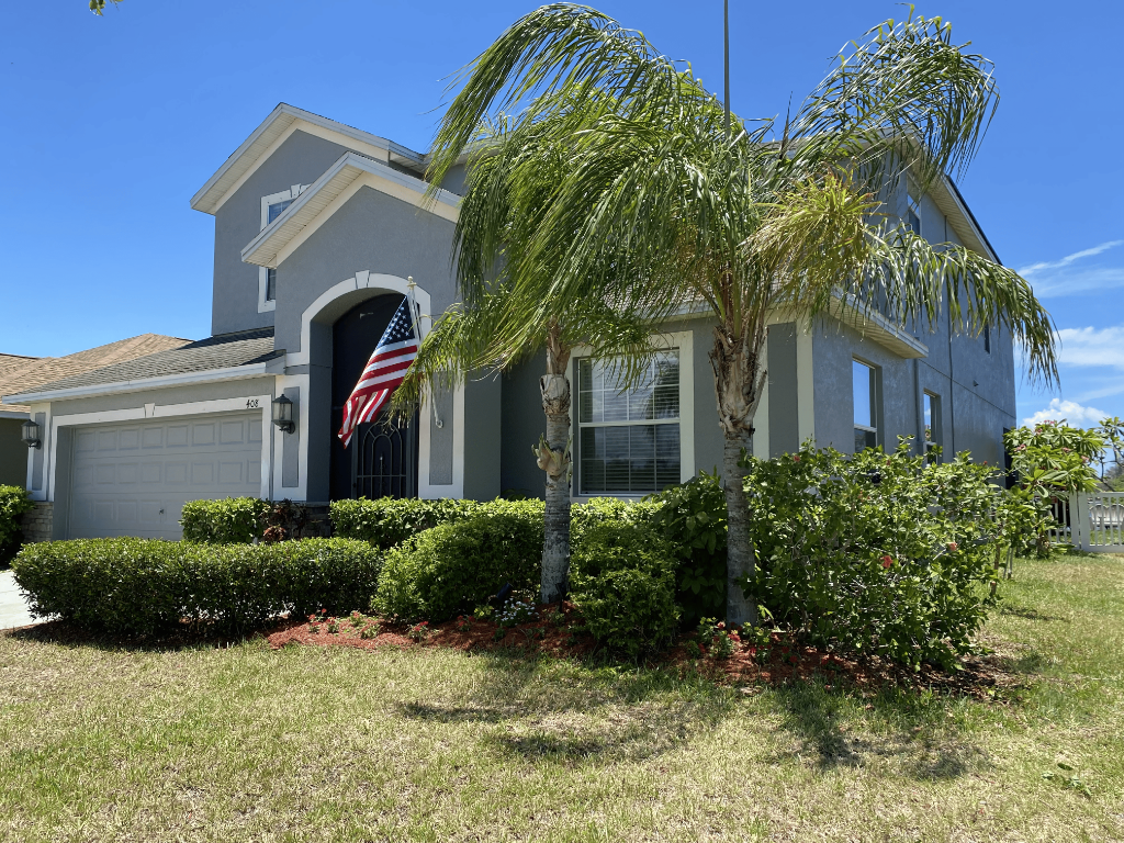 Sunset Haven home exterior with palm trees and American flag, 408 19th St NW Ruskin Florida