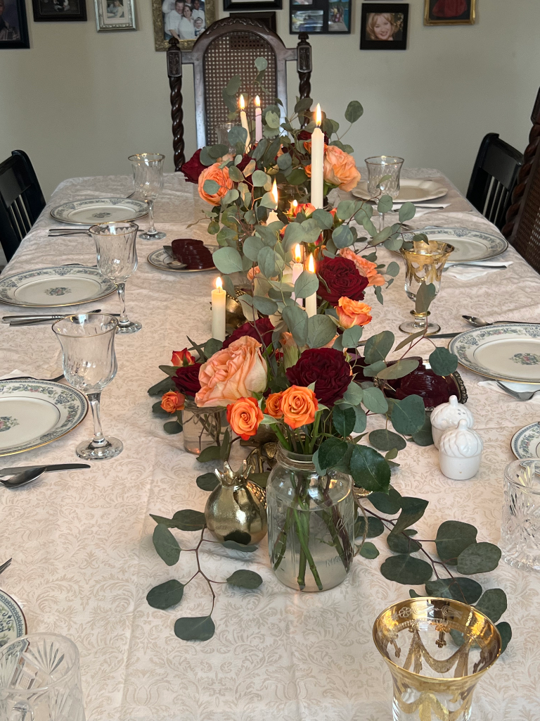 Dining table set for a holiday feast with fine china and rose centerpiece