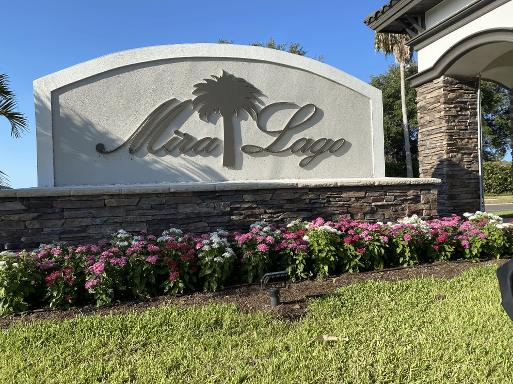 Mira Lago community monument sign with palm tree logo on stone base