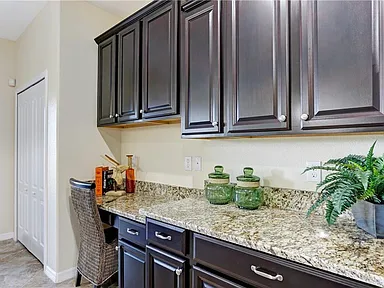 Butler pantry and built-in desk nook with espresso cabinets and granite