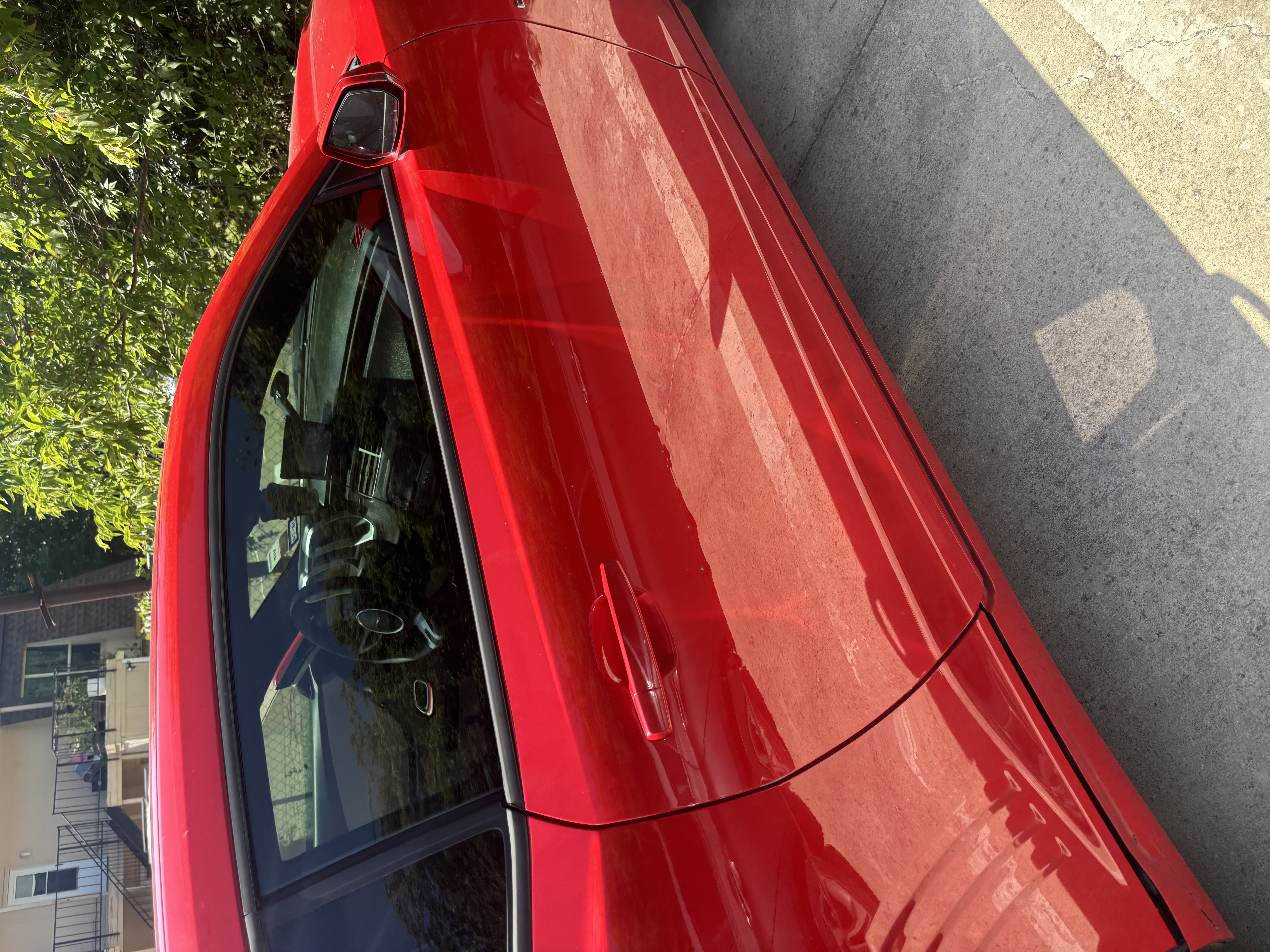 Glossy red car door and mirror detail