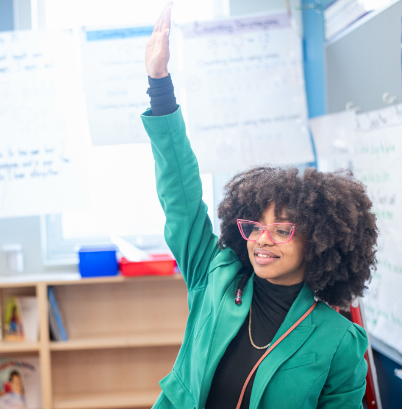 Mrs. Hanks teaching in a classroom wearing a green blazer