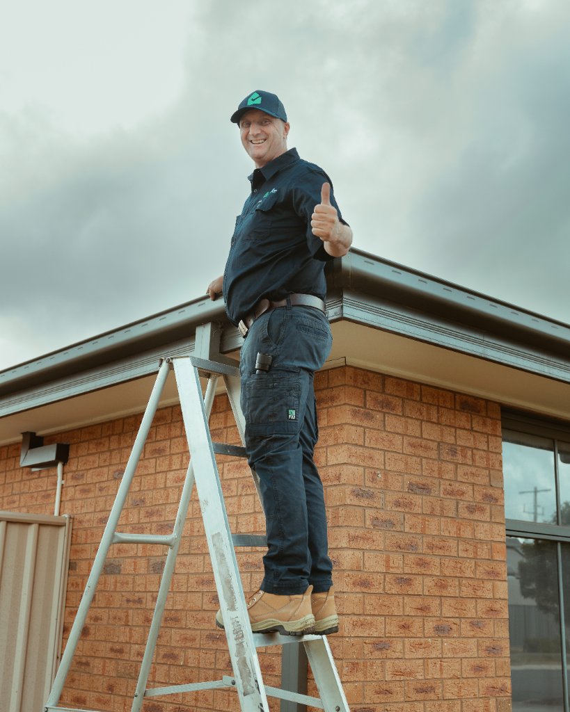 Building inspector on ladder giving thumbs up