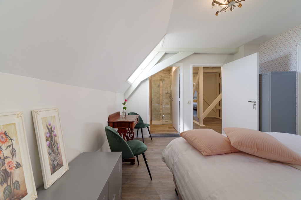 Sfeervolle kamer met groene stoelen en uitzicht op de badkamer bij Herberg De Griffioen