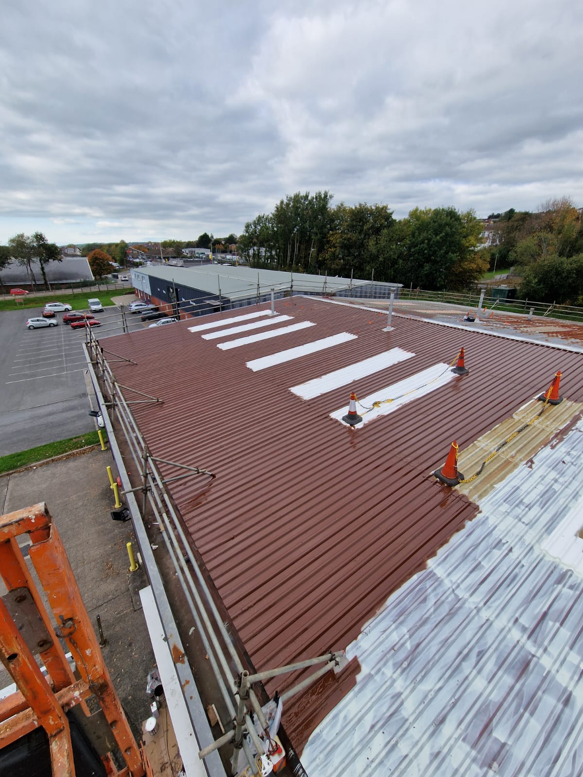 Primer application across prepared commercial metal roofing