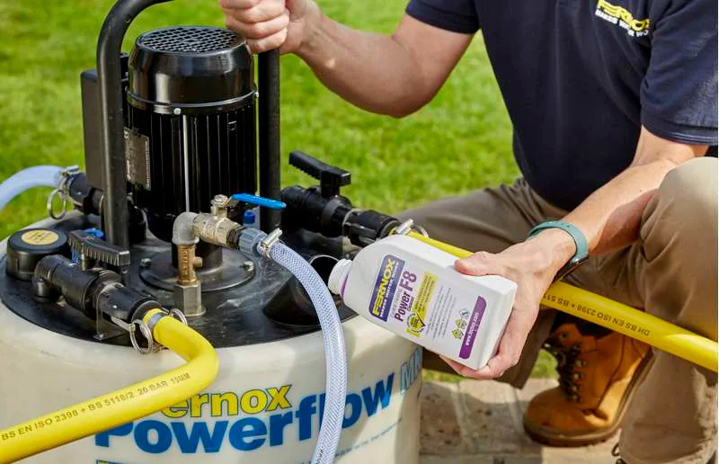 Power flushing — RARE Plumbing London RARE Plumbing London engineer power flushing a heating system to remove sludge and restore radiator efficiency