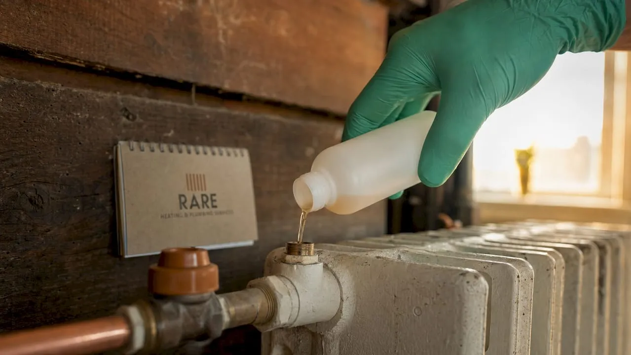 Hand pouring inhibitor into radiator bleed valve