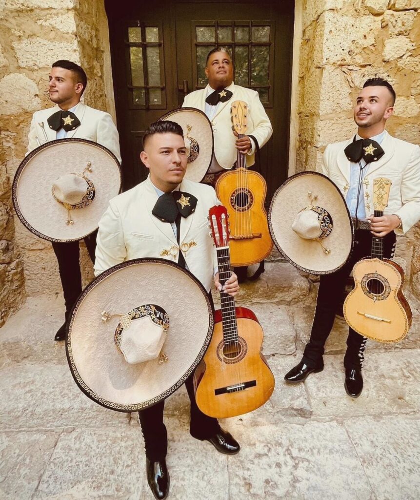 Mariachi Estrellas de Madrid cuarteto con sombreros y guitarras posando en exterior