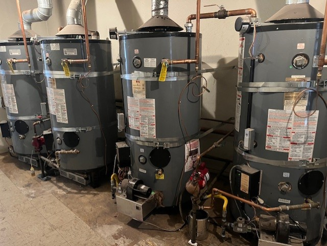 Commercial-grade water heater bank with copper piping and gas lines