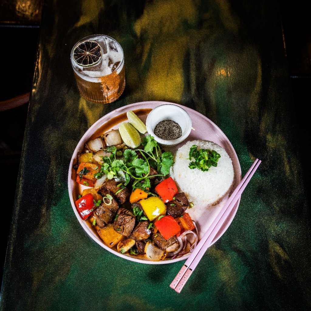 Shaking beef with drink overhead