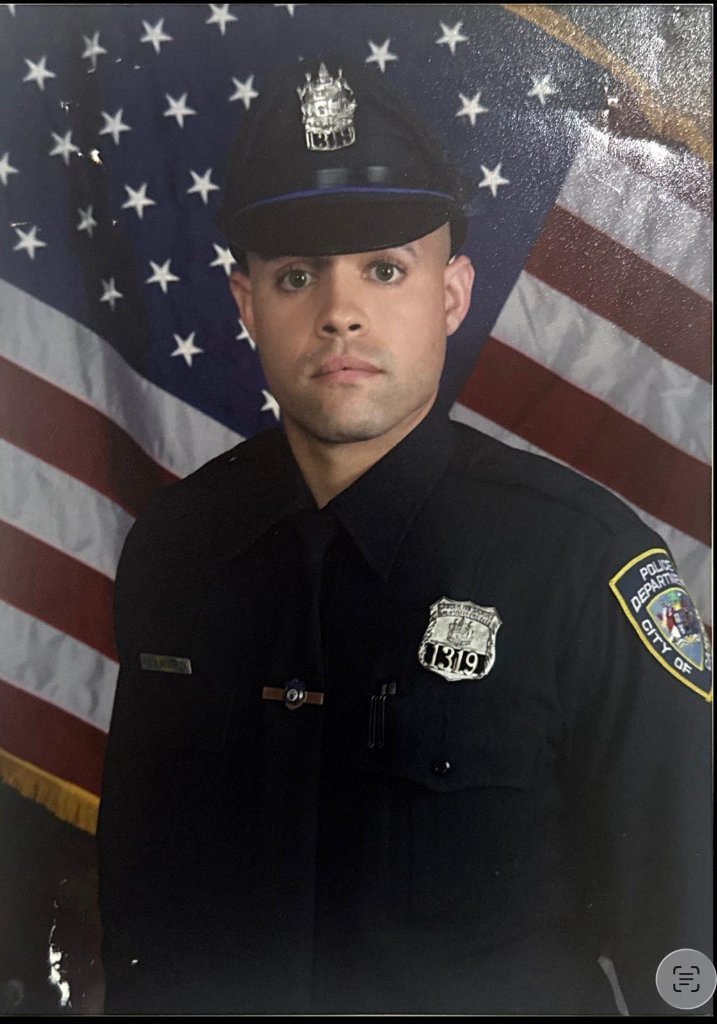 Heriberto Inostroza in police uniform before American flag