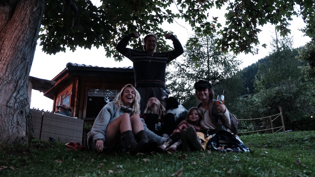 Friends and dog relaxing on the lawn at dusk