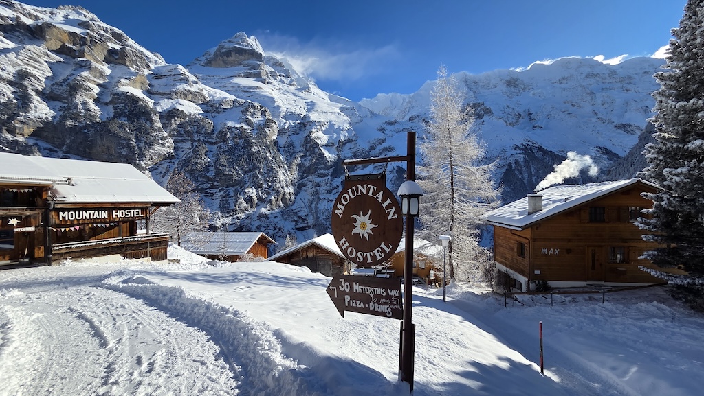 Mountain Hostel sign in the snow in winter