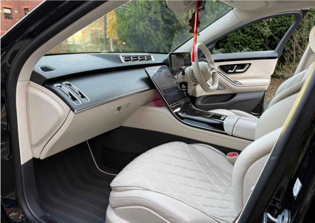 Professional chauffeur opening door of luxury vehicle