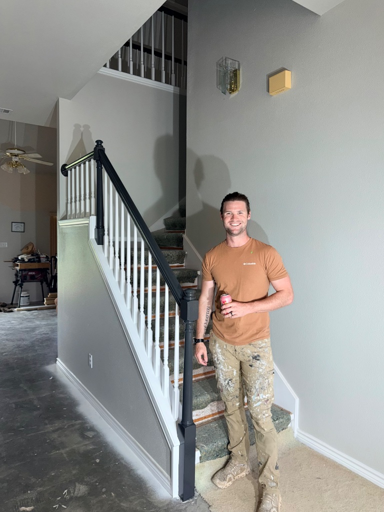 Aaron Shaver with a satisfied homeowner in front of their freshly painted home