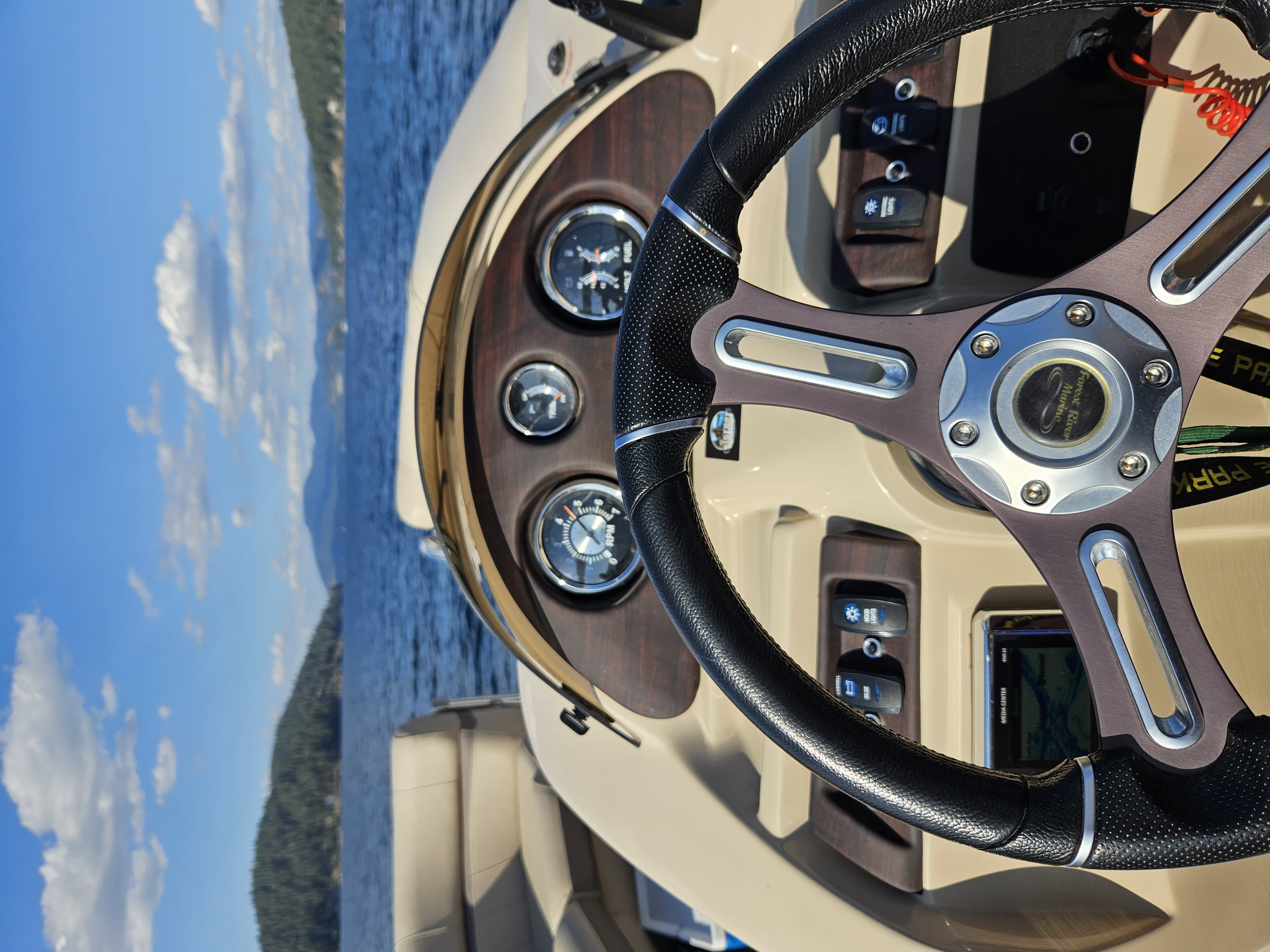 Helm and dashboard of the Berkshire pontoon with steering wheel and gauges