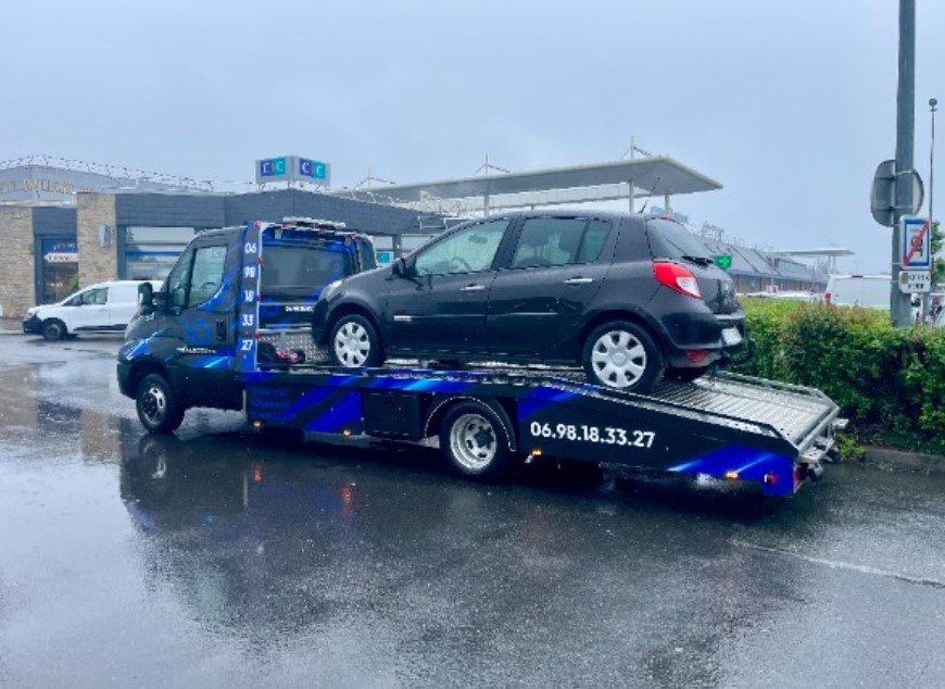 Camion plateau VD Transports transportant une Renault Clio