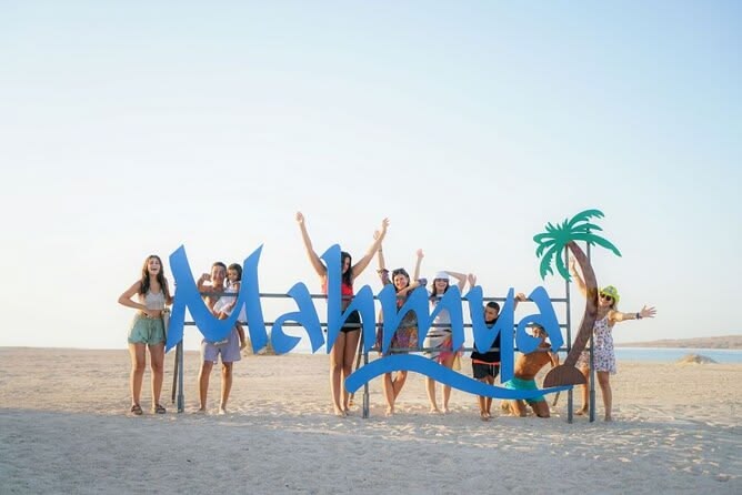 Mahroussa Island sign on the beach with group of travellers