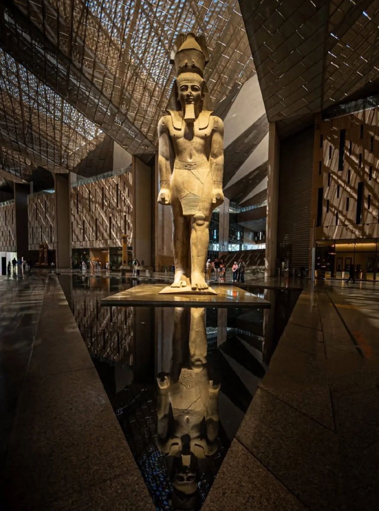 Grand Egyptian Museum Ramesses II statue reflected in dark floor