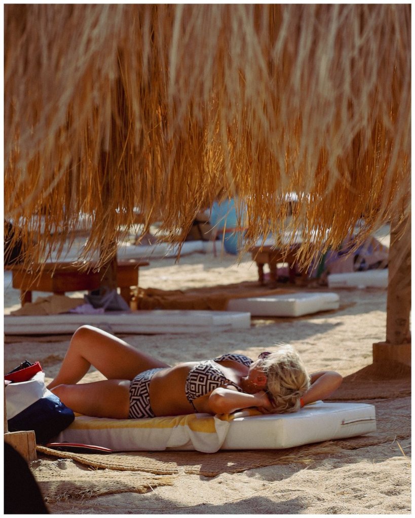 Sunbathing on a beach bed under palm shade
