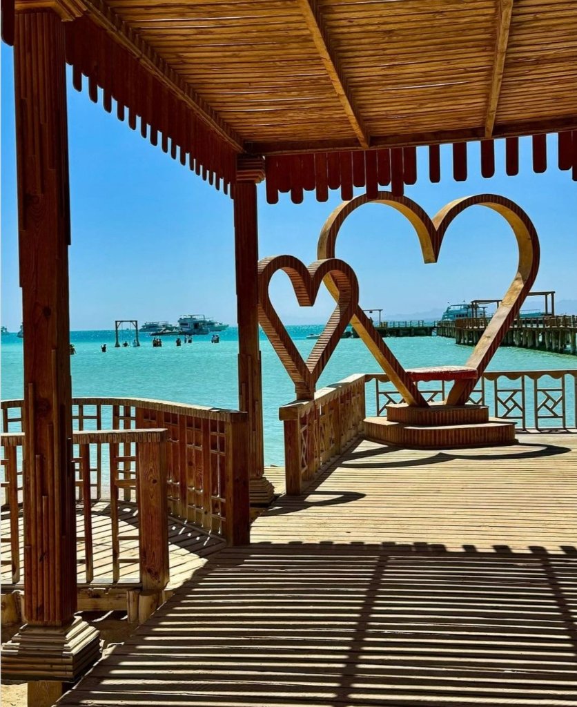 Wooden heart sculptures on the pier overlooking the turquoise Red Sea