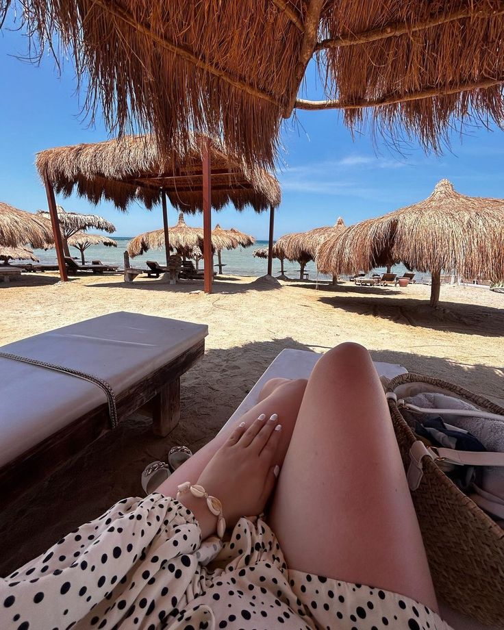 Relaxing on sun loungers under thatched umbrellas at the beach
