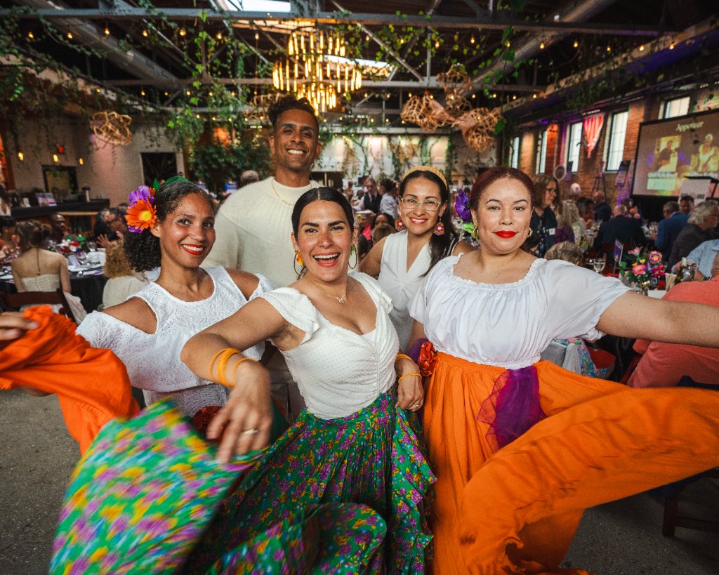 Art vs. Food — Panadanza dancers in colorful skirts smiling for the camera