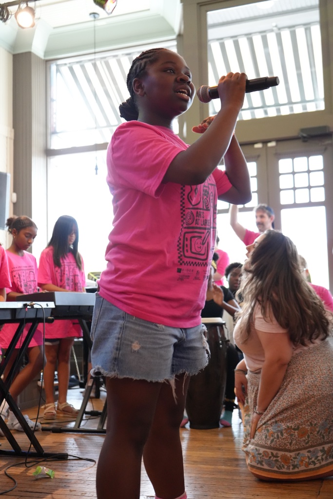 Young singer performing with a microphone at summer camp