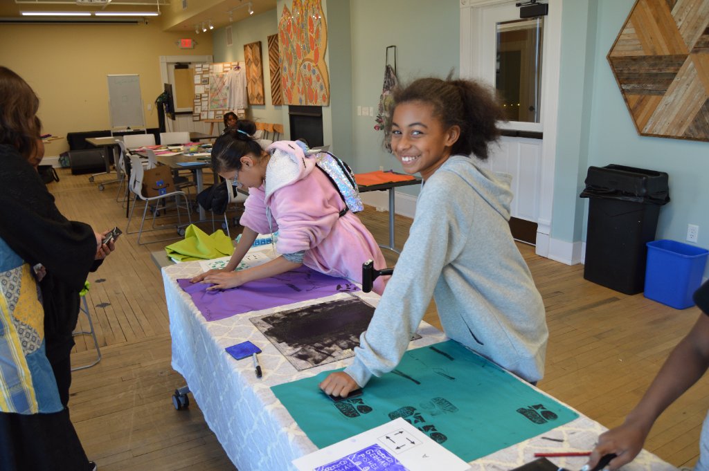 Students printmaking on colorful fabric in the studio