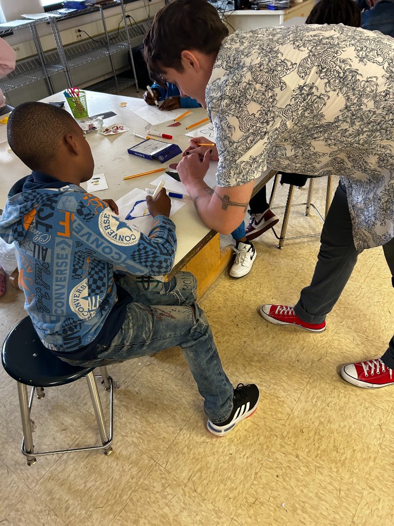 Teaching artist working one-on-one with a young student on a drawing