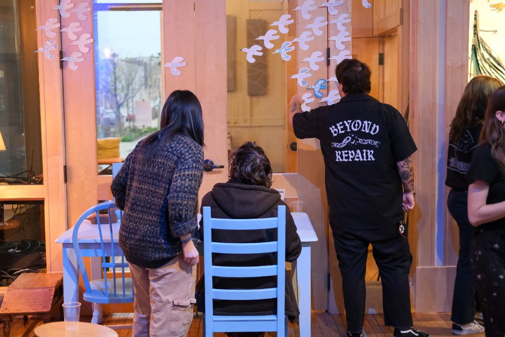 Visitors viewing a suspended sculpture at a gallery opening