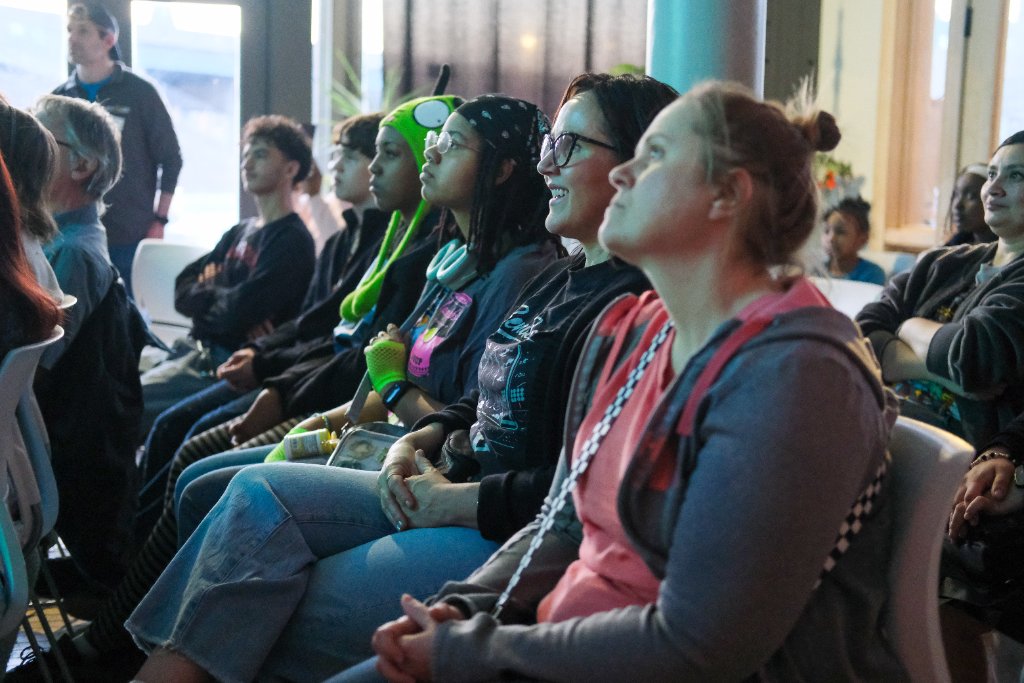Artist sketching a mural design on a blue gallery wall