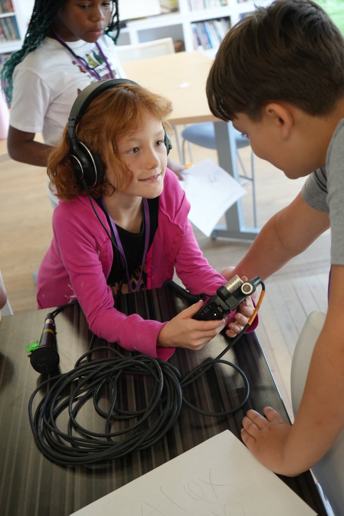 A camper learning audio recording with a mentor