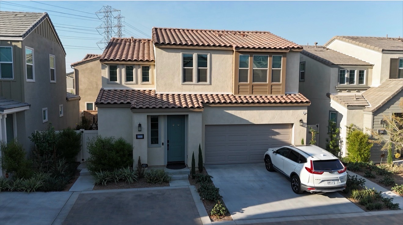 Two-story home with clay tile roof and covered entry