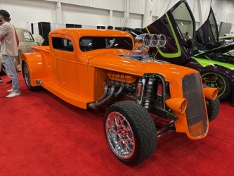 Orange 3-window coupe — blown, side pipes, SEMA show floor