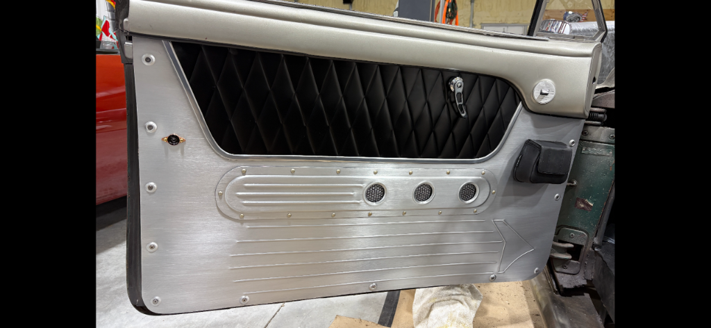 Finished panel installed — brushed aluminum lower, diamond-stitch black upper, riveted detail