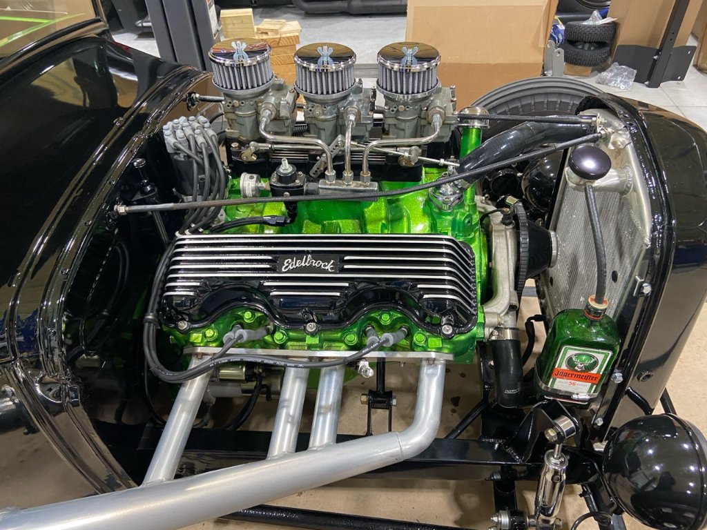 Engine bay — Edelbrock-topped V8, triple carburetors, show-quality detail