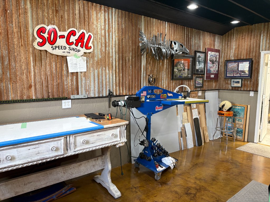 Clean room — green retro fridge, wood cabinets, license plate backsplash, bead roller