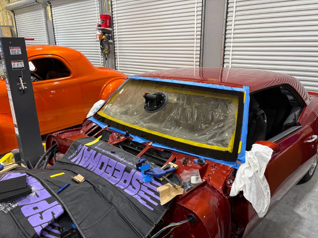 Windshield installation in progress — suction cup placement, body protected