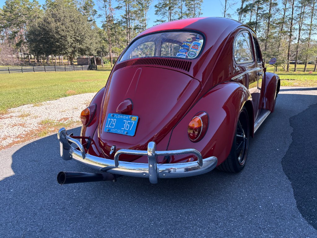 Rear three-quarter — slammed stance, black wheels, side exhaust, Florida antique plates