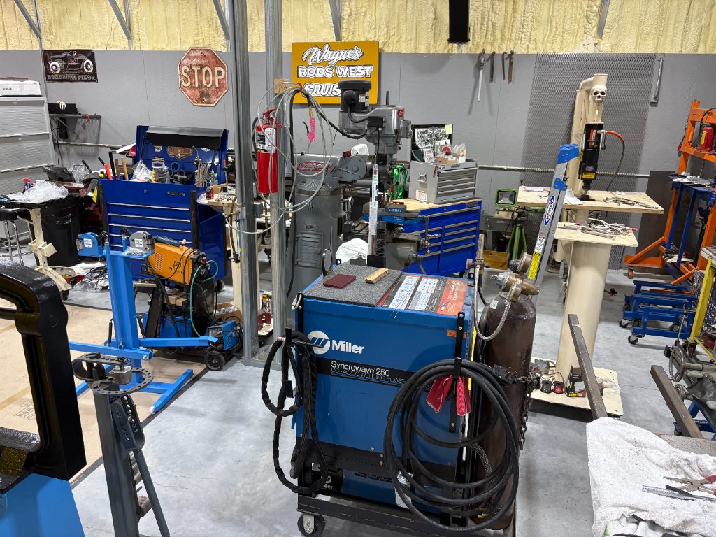 Miller Syncrowave 250 TIG welder — Wayne's Rods West Cruise signage, full fab zone