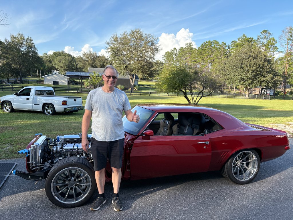 Happy customer — completed Camaro with fresh glass at Waynes Rods West