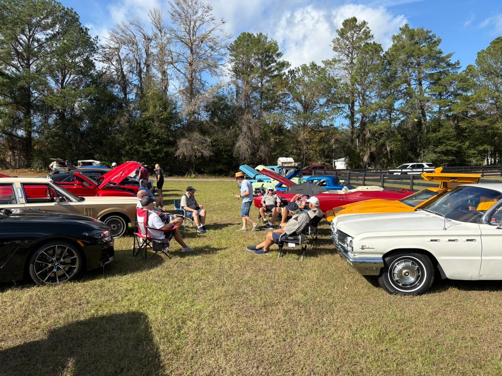 Show field — classics lined up, hoods up, enjoying the Florida sun