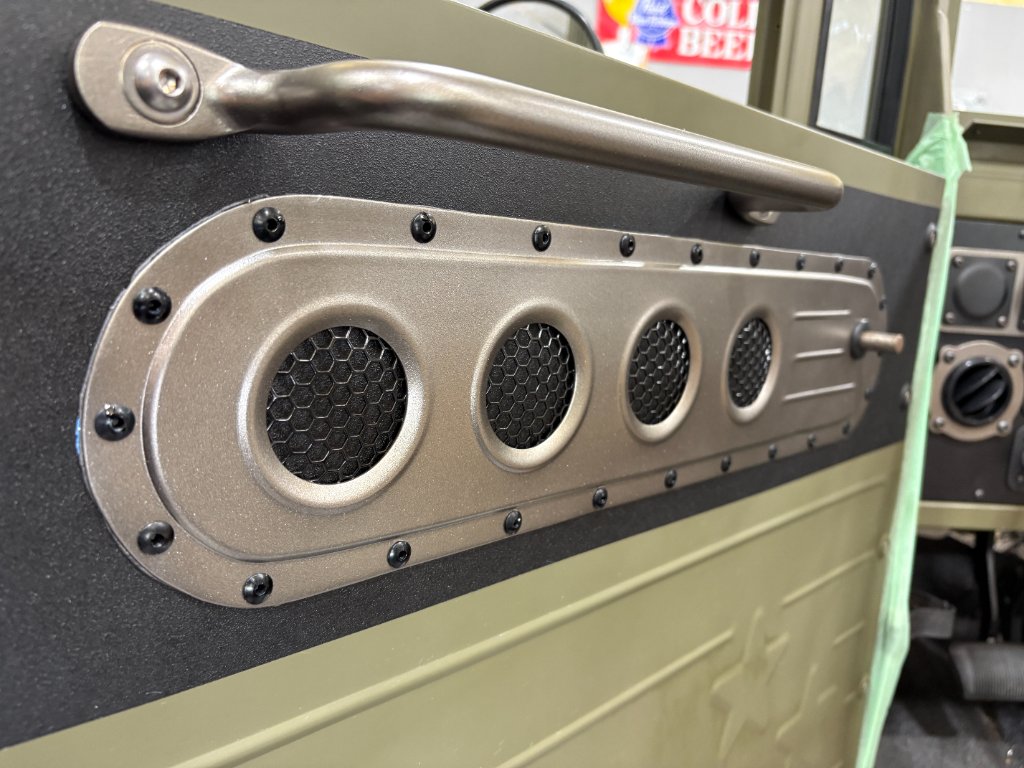 Driver's door detail — speaker panel close-up showing rivet pattern and mesh grilles