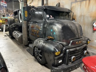 Black GMC semi rat rod — slammed cab-over, Joker-style graphics