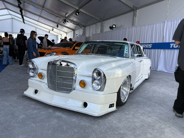 White widebody Mercedes 300 — bagged, SEMA outdoor tent