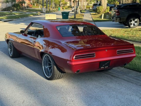 Rear three-quarter — candy red finish, custom wheels, completed build